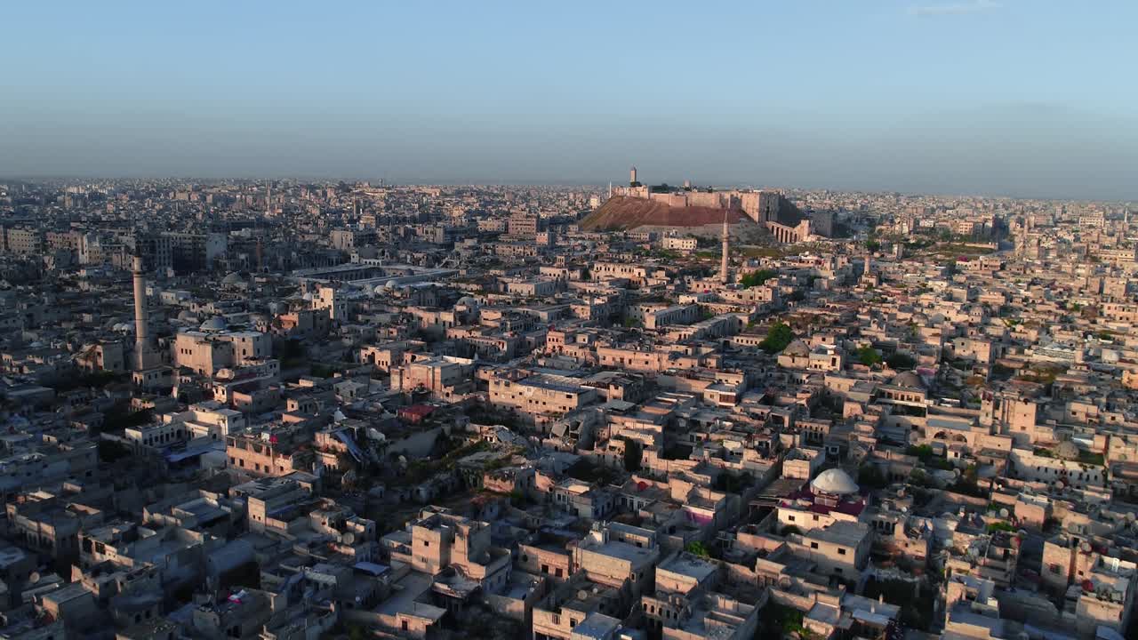 vista aérea con un dron de la ciudadela de alepo bajo la puesta de sol. podemos ver la ciudad siria en todo el horizonte 4k