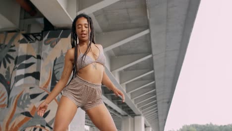 woman dancing under a bridge