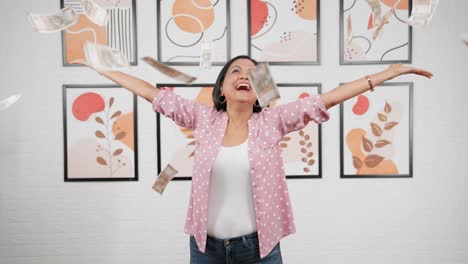 modern indian woman throwing money in air