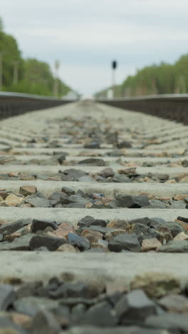 vista rápida de cerca de una vía ferroviaria centrada en las travesas de hormigón y el lastre de grava, con perspectiva que conduce hacia el horizonte