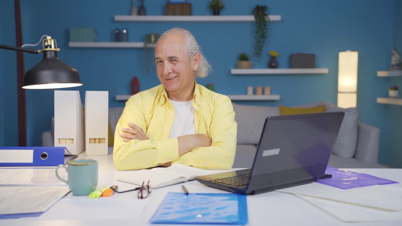 Home office worker old man looking smugly at camera.
