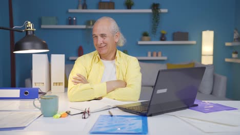 Home office worker old man looking smugly at camera.