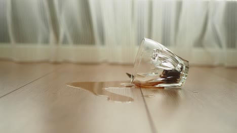 spilled glass of tea on a wooden floor