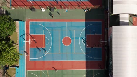 aerial view of young athletes playing basketball in an open summer playground