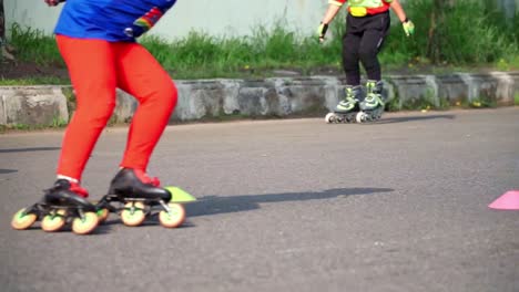 a row of children are practicing roller skating on a paved area.