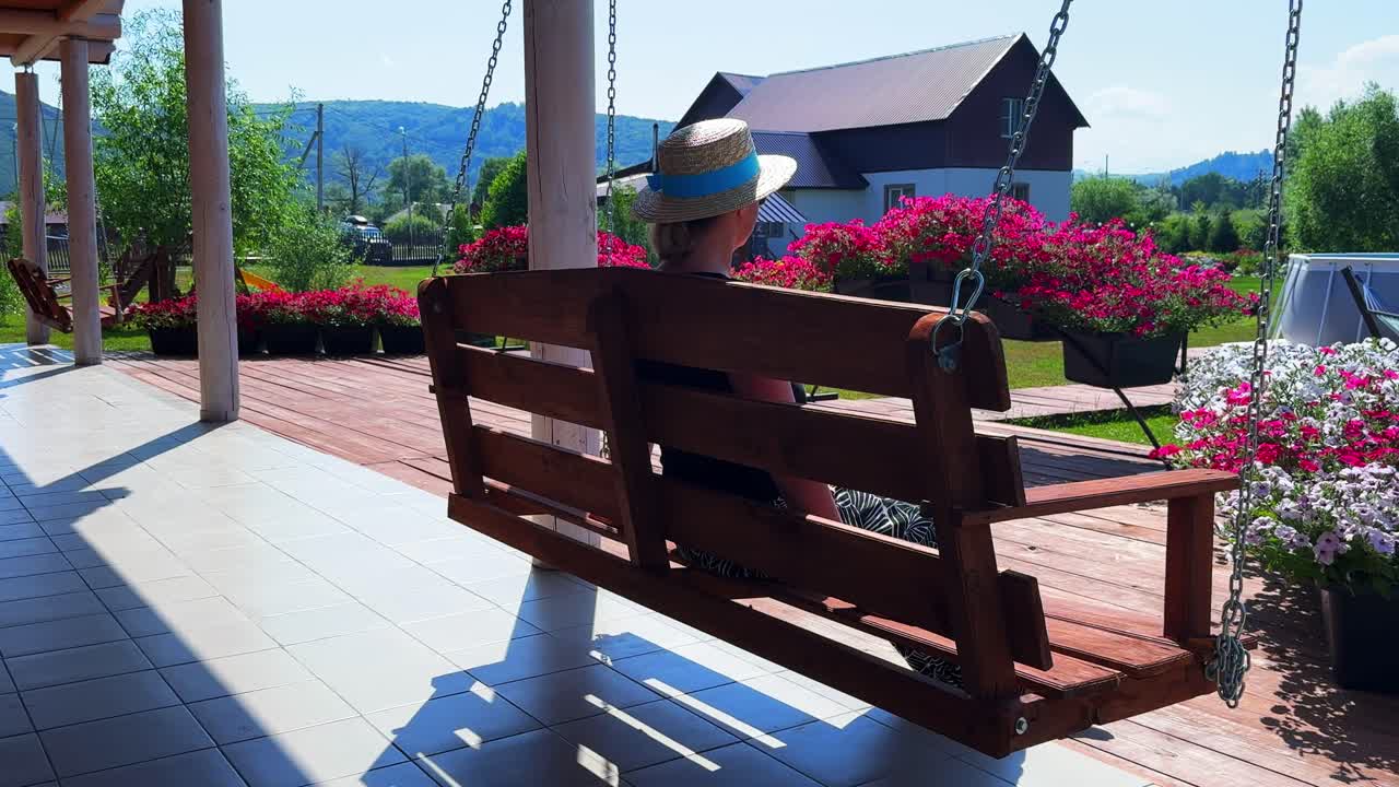 A Serene Afternoon Scene: A Person Enjoying a Peaceful Moment on a Swing Amidst Lush Gardens and Breathtaking Scenery