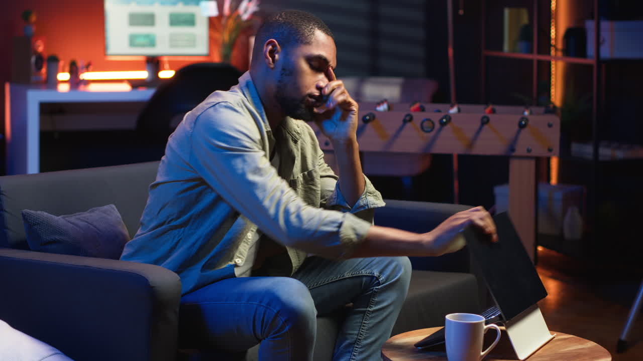 Vertical Video Tired black man failing some tasks and struggling to focus at home