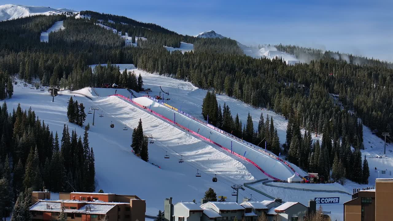Copper Mountain Resort center village aerial drone chairlifts gondola Ikon Pass Alterra snowboarding snow ski riding trails morning winter solstice December halfpipe snow guns trees upward motion