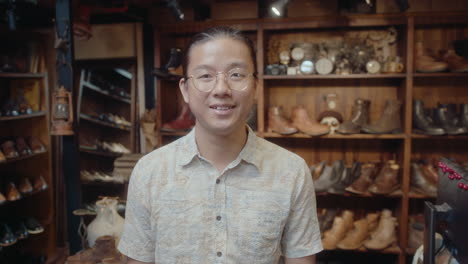 happy asian man posing for camera in antiques store