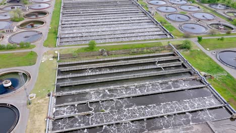 aerial shot of a wastewater treatment plant and distant skyline. big city waste processing concept