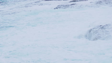 grandes olas marinas que cubren la costa rocosa creando espuma y niebla