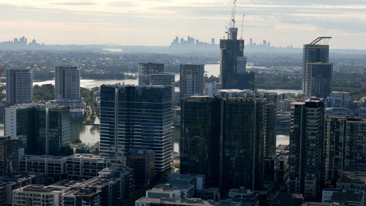 도시 창: 아침 빛에 멀리 떨어진 도시 배경과 함께 강 위에 아오르는 반이는 마천루