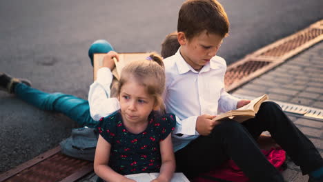 Joven-Traviesa-Habla-Con-Hermanos-Leyendo-Libros-Cerca