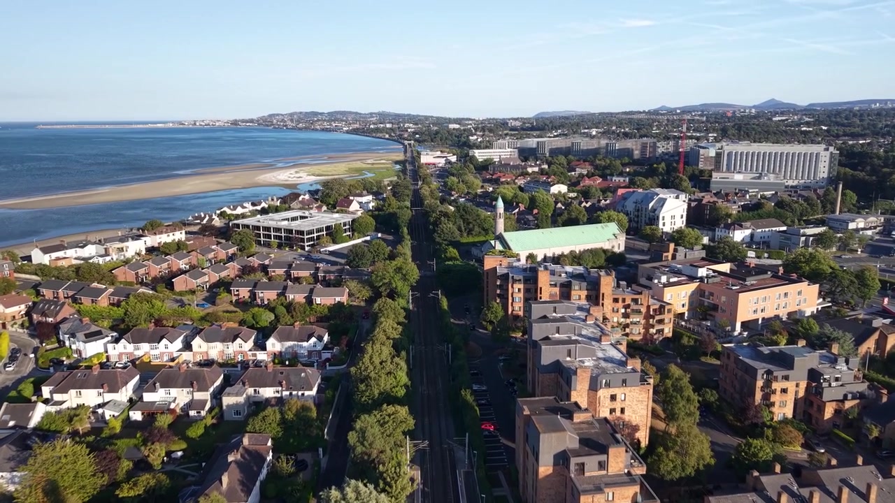 Paesaggio urbano costiero di Dublino verso Blackrock e la stazione di Booterstown alla luce del sole serale.