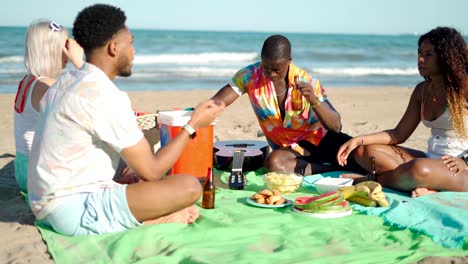 multiracial friends having picnic on beach