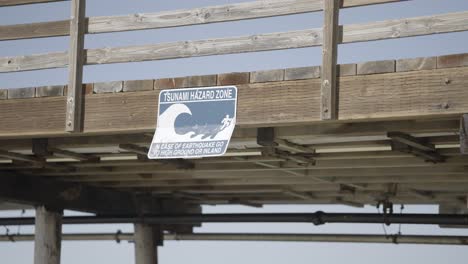 tsunami hazard zone sign on california pier with a wave on sign