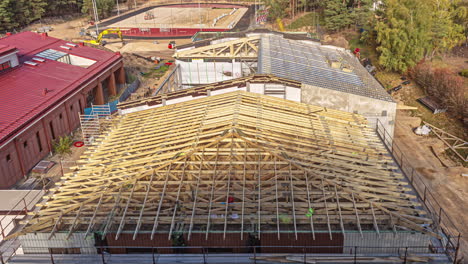 Workers-Working-At-The-Construction-Site,-Working-And-Installing-The-Wooden-Frame-And-Trusses-Of-Roof-Of-Building