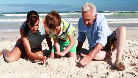familia feliz jugando en la arena en la playa