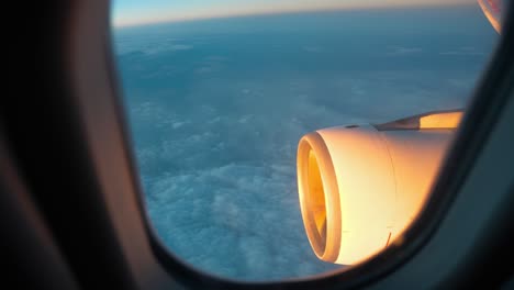 Vista-De-La-Ventana-Del-Avión-Que-Muestra-La-Iluminación-De-La-Turbina-Al-Atardecer.