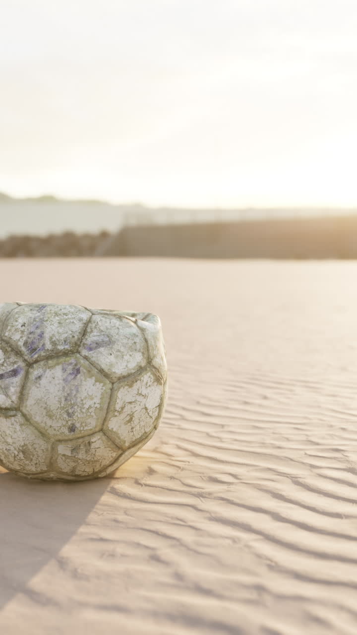 바가 에 있는 모래 에 날씨 가 변한 축구 공 이 놓여 있다