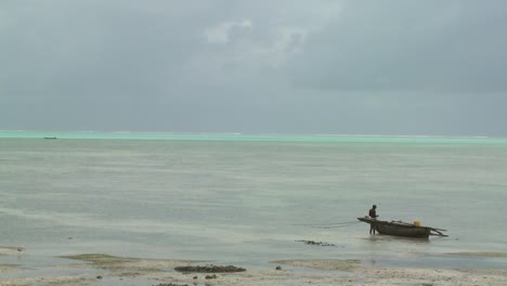 un nativo distante se encuentra junto a su canoa en una isla tropical paradisíaca