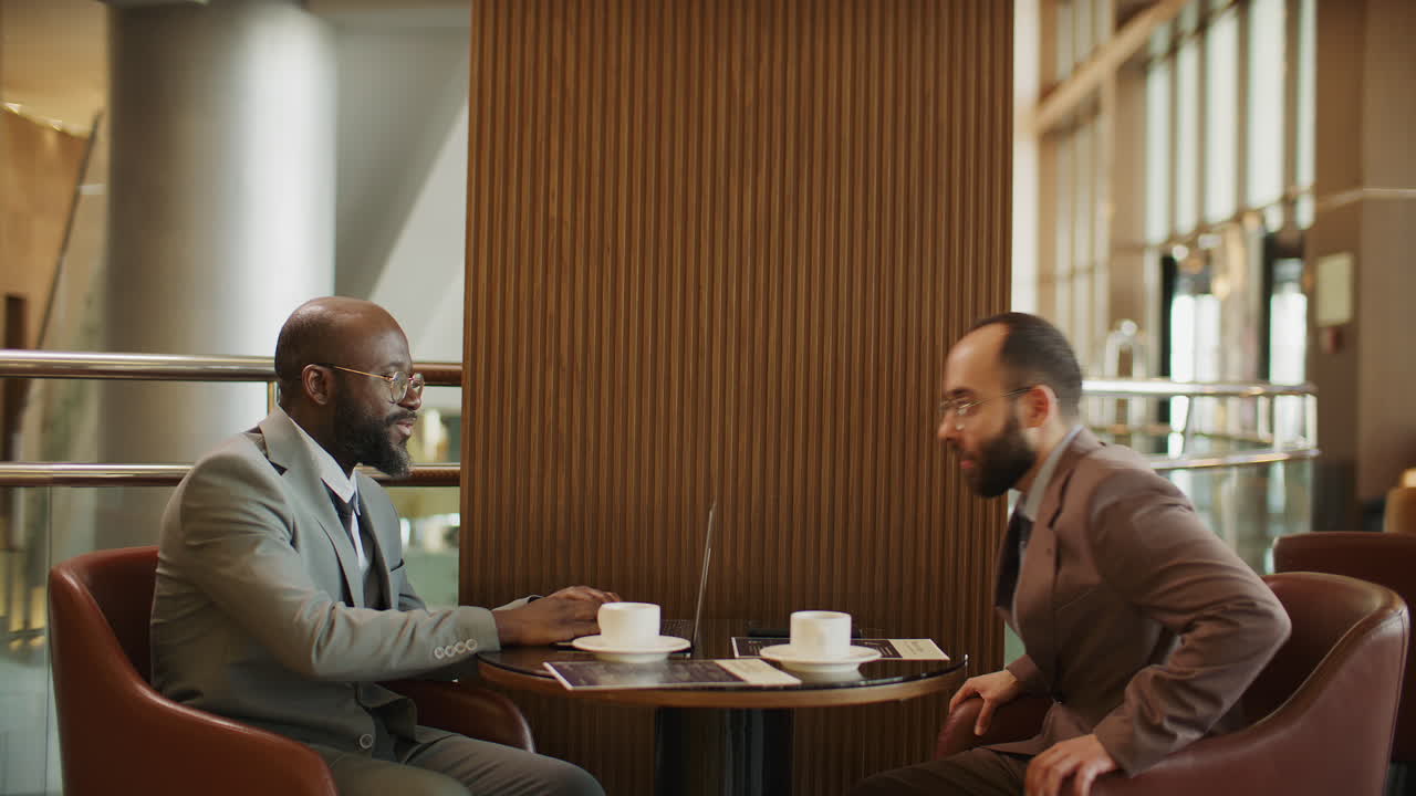 African American Business Advisor Meeting with Client in Hotel Lounge