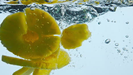 pieces pineapple dropped water in super slow motion close up. ananas floating.