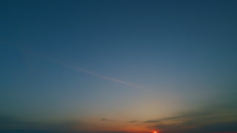 sun goes up over horizon. colorful sunrise blue sky with pastel orange clouds in golden yellow cloudscape. time lapse.