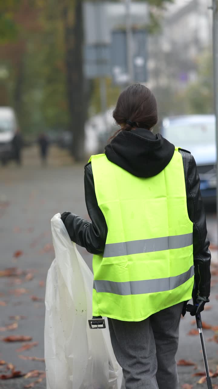 mujer limpiando la basura en la calle