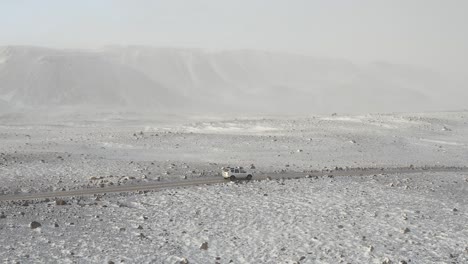 Side-Pan-Aerial-of-an-off-Road-Vehicle-Driving-through-F-Road-during-a-Snow-Storm-in-wilderness-Iceland-Ok-Glaciar