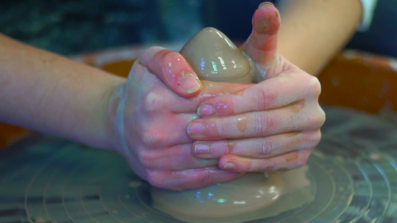 una chica acumula arcilla para prepararla y convertirla en una olla