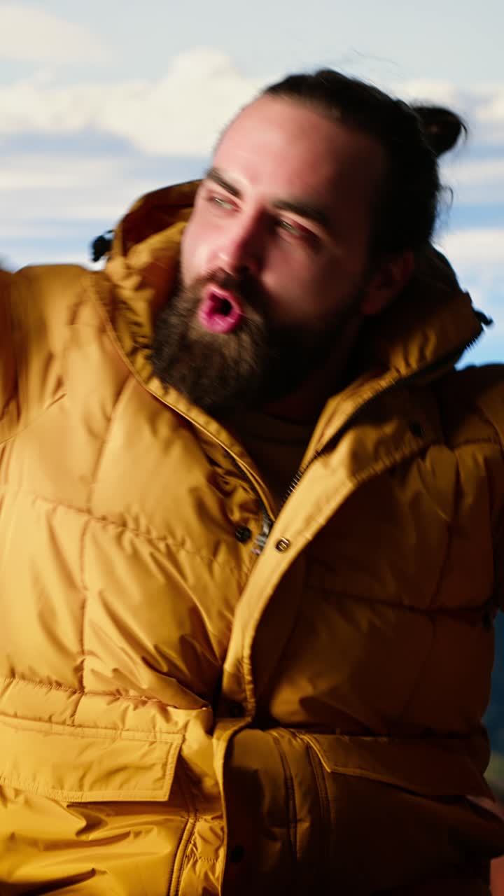 Man in Yellow Puffer Jacket Climbing and Enjoying Mountain View