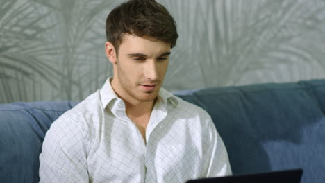 happy businessman messaging computer indoors. cheerful guy looking laptop screen