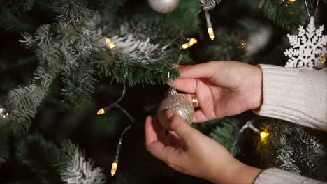 manos decorando un árbol de navidad