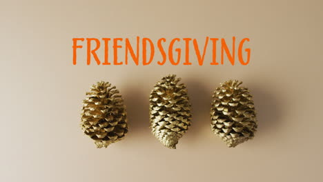 animation of friendsgiving text and pine cones on brown background