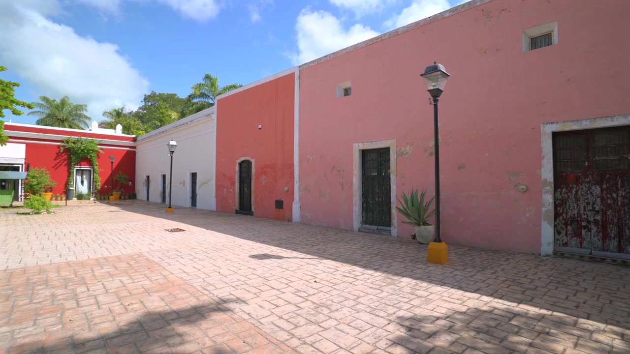 Toma panorámica a la izquierda de fachadas históricas y coloridas de edificios coloniales a lo largo de la calle Calzada de los Frailes en Valladolid, Yucatán, México