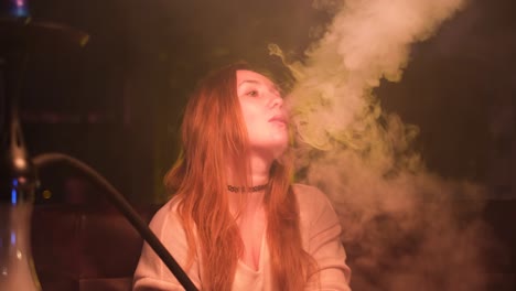 woman smoking hookah in a night club