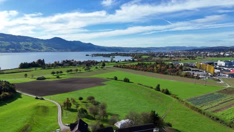 Vuelo-Aéreo-Sobre-Serenas-Tierras-De-Cultivo-Junto-Al-Lago-De-Constanza,-Cerca-De-Bollingen,-Suiza