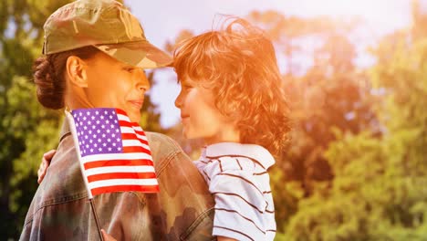 Animation-of-female-soldier-embracing-smiling-son-with-american-flag-over-trees-and-sky