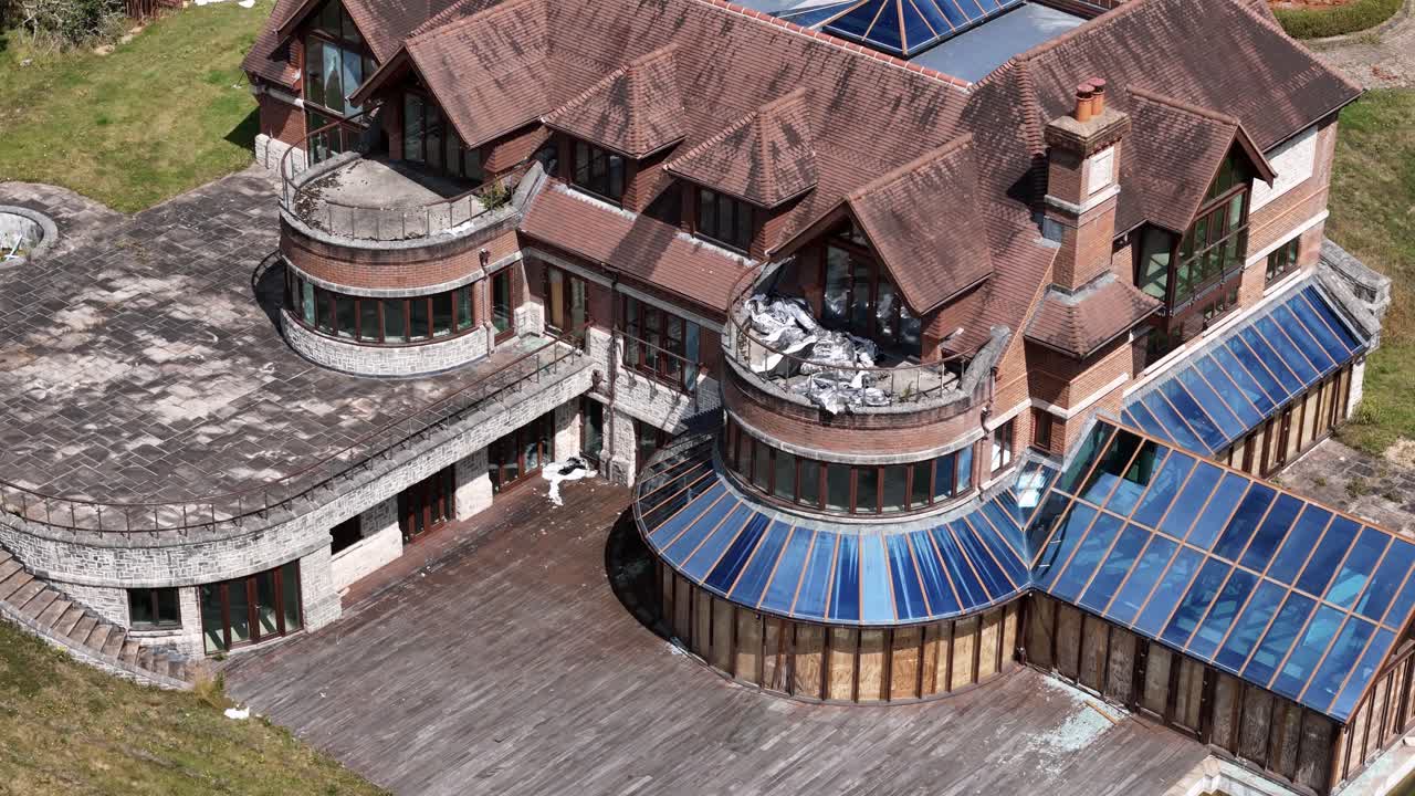 Expensive luxury celebrity mansion aerial view looking down over tinted glass rooftop