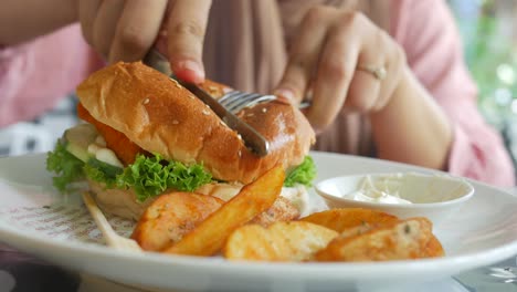 woman eating a fish burger and fries