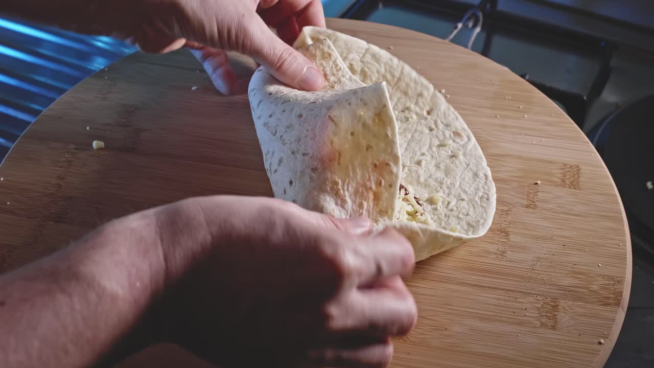 envoltura de tortilla enrollada rellena de pechuga de pollo frita, huevos duros, queso y salsa barbacoa