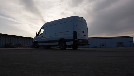 white delivery van parked in an industrial area at sunset or sunrise