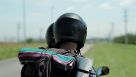 Eine-Stationäre-Aufnahme-Von-Zwei-Personen,-Die-Auf-Einem-Motorrad-Mit-Blick-Auf-Die-Straße-Fahren