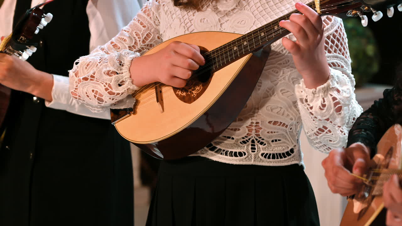 Close-up of three women playing the mandolin