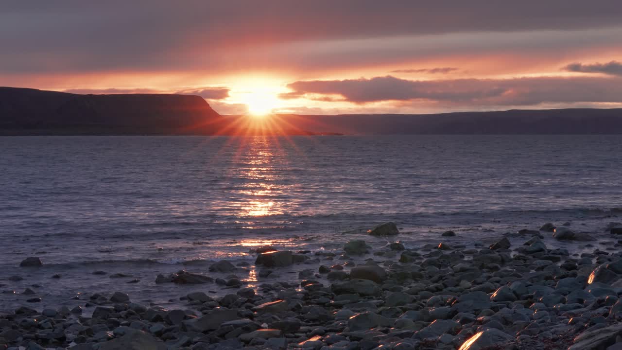Laskeva aurinko laskee horisonttiin heittäen lämmintä valoa maiseman ylle