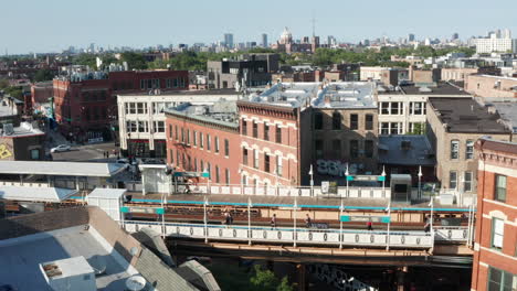 a slow, daytime, aerial cinematic reveal of a cityscape skyline behind a rail train station in chicago