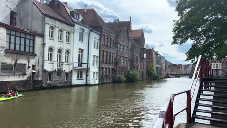 Menschen,-Die-Am-Fluss-Leie-Entlang-Der-Häuser-Kajak-Fahren