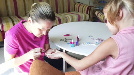 madre e hija haciendo arte de uñas juntos
