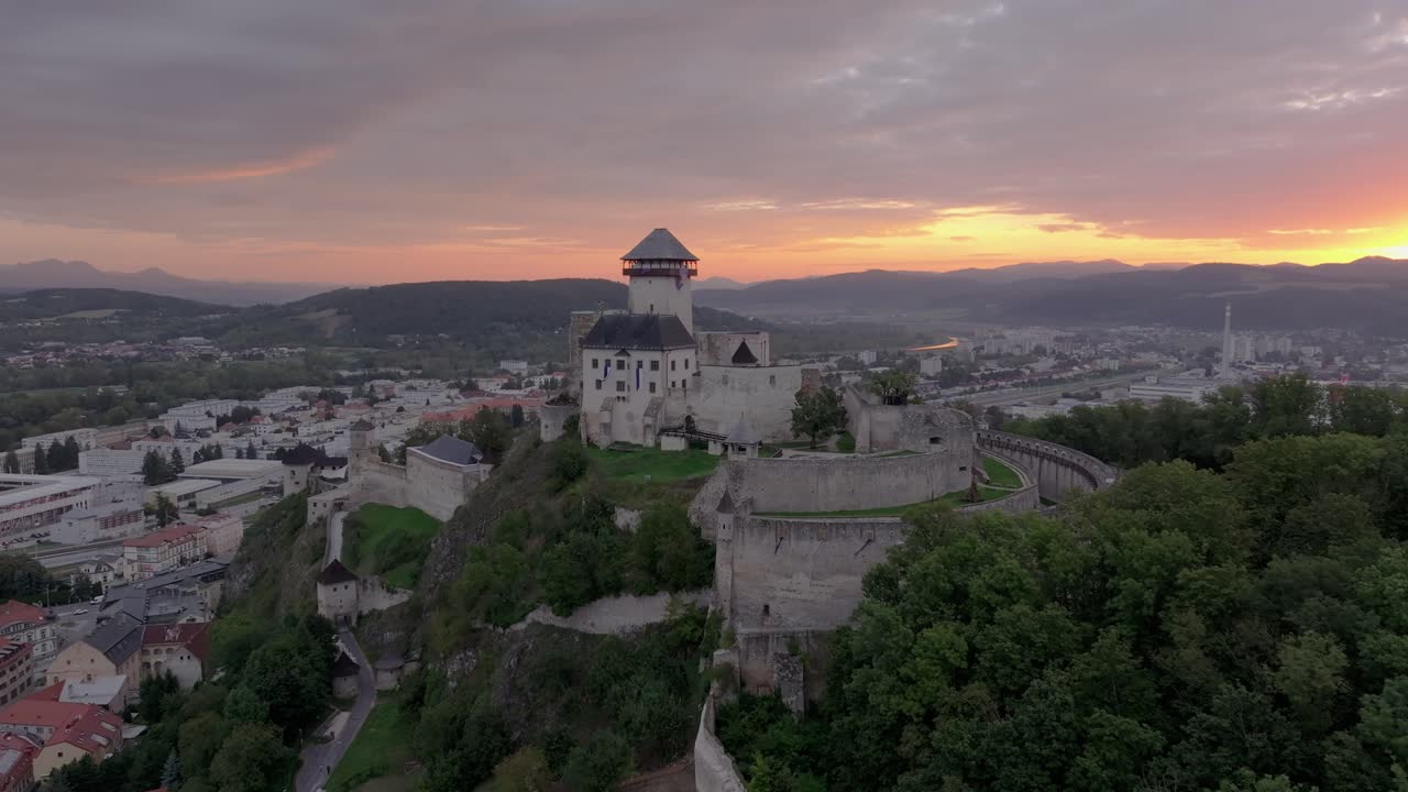 Imagem de drone do Castelo de Trencin erguendo-se sobre uma paisagem urbana tranquila